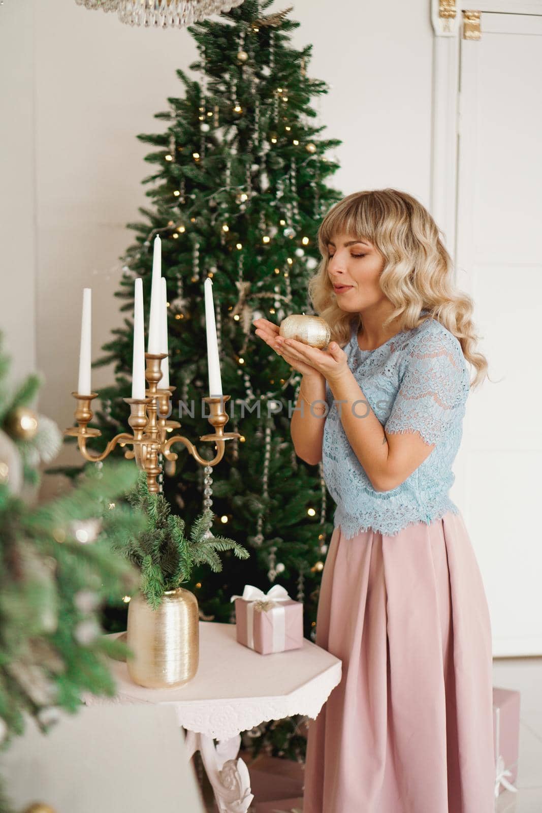 Attractive young woman smiling while holding a candle celebrating Christmas by natali_brill