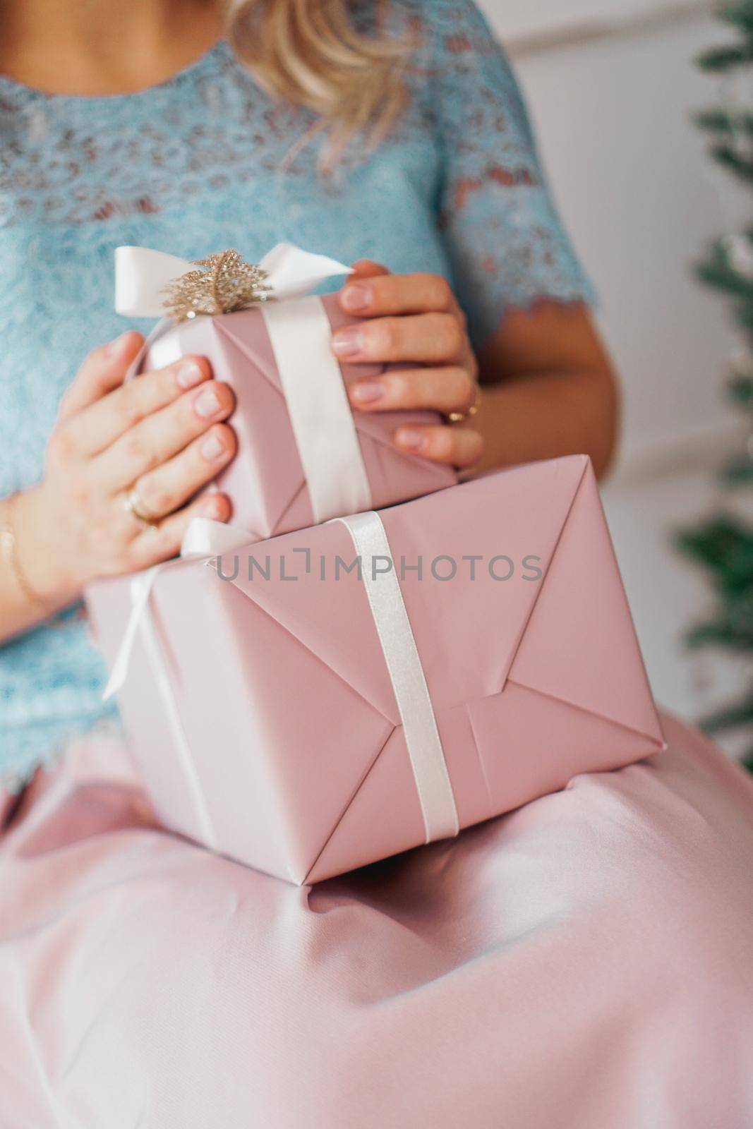 Hands holding gift present. Closeup of Female hands giving the gift in the New Year interior