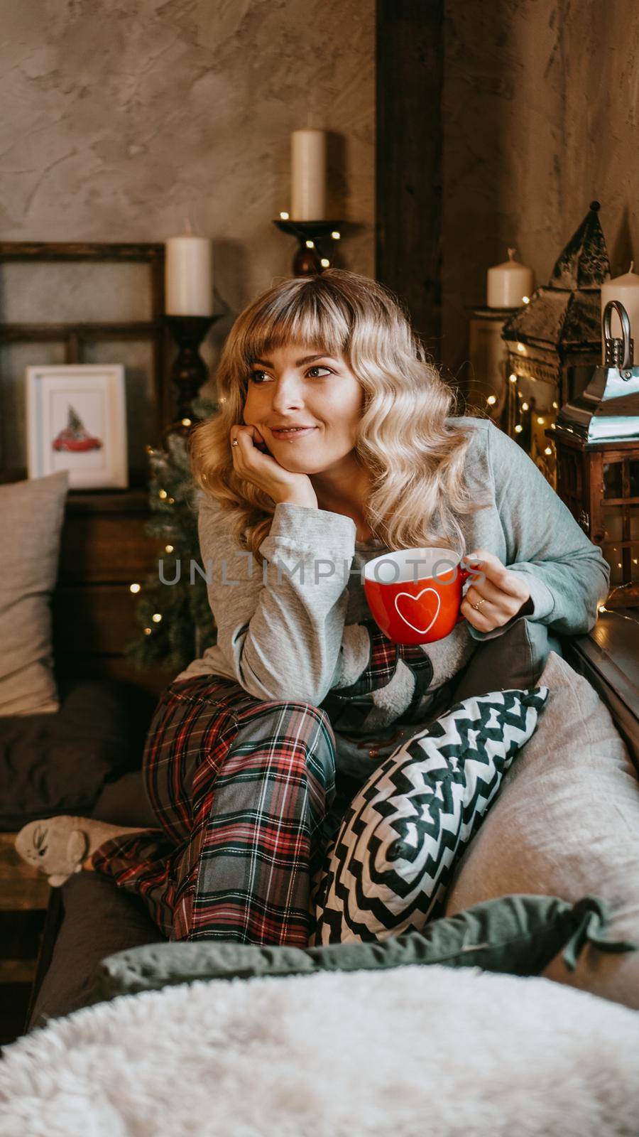 Young woman with cup of tea in Christmas cozy interior. Make a wish and dream by natali_brill