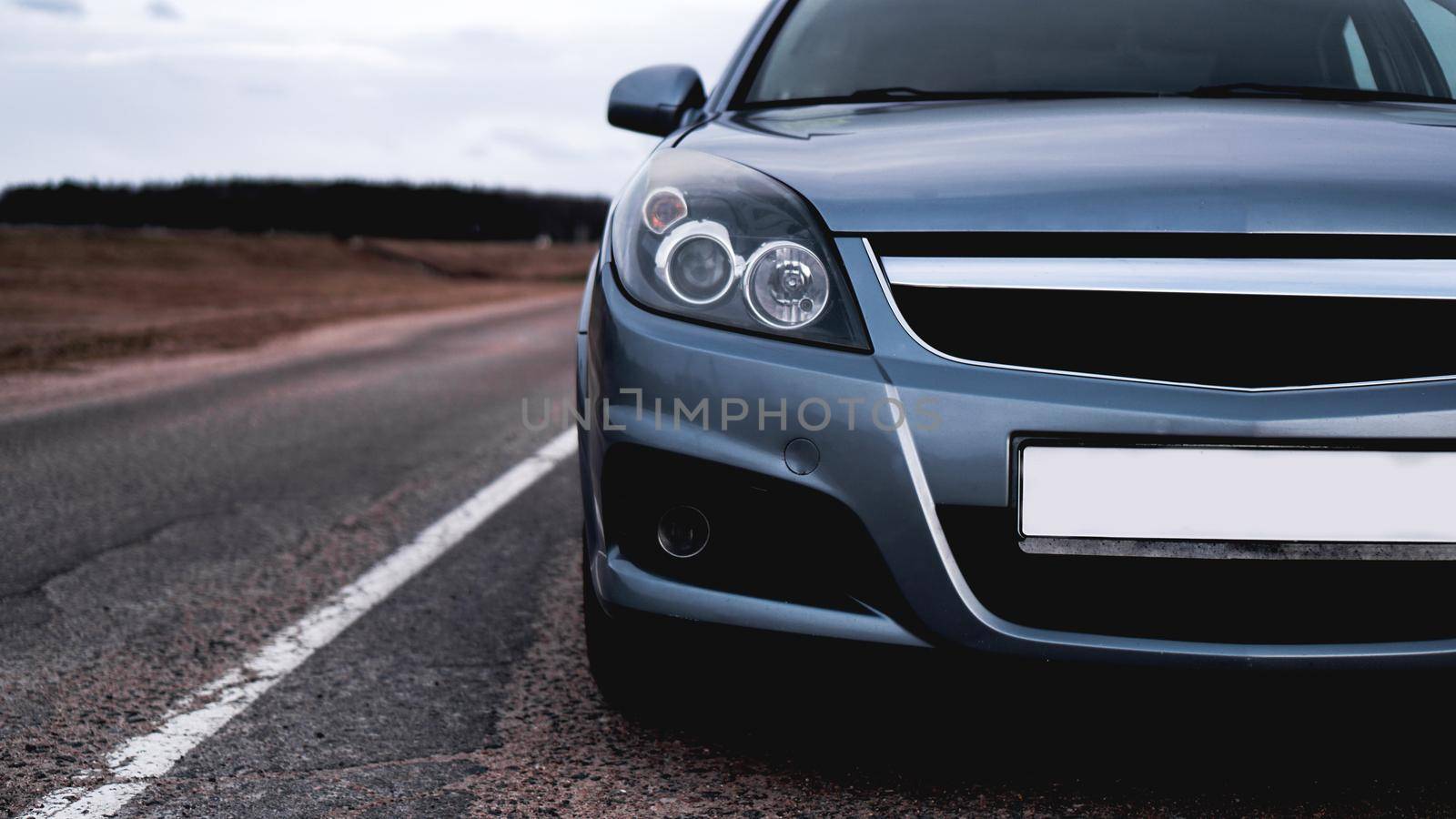 Close up front of new silver car parking on road by natali_brill