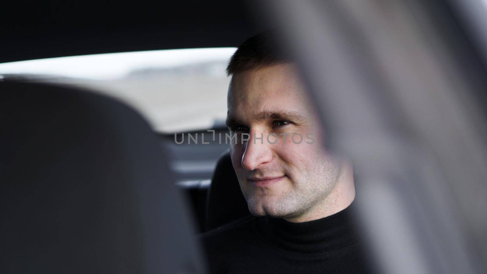Smiling business man sitting in the back seat of a car by natali_brill