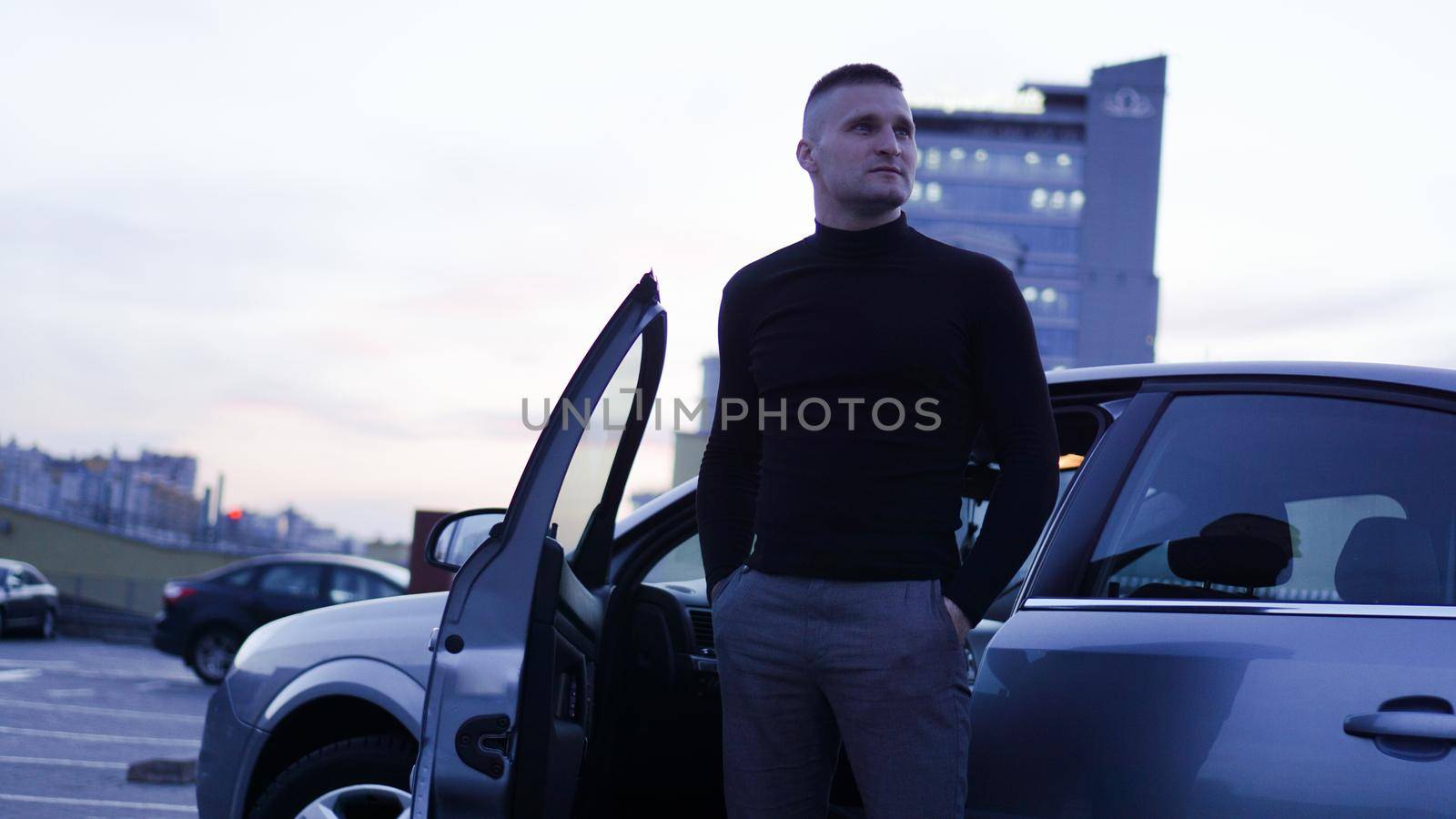 Handsome businessman near his car in the city