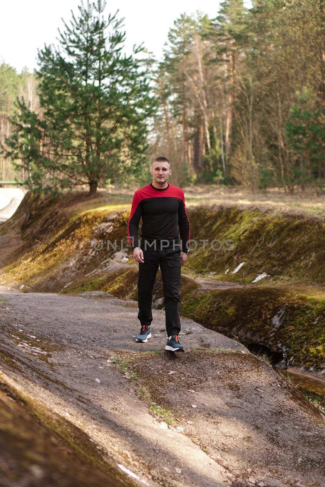 Young male athlete running in forest. Man jogging in the morning in the forest or park