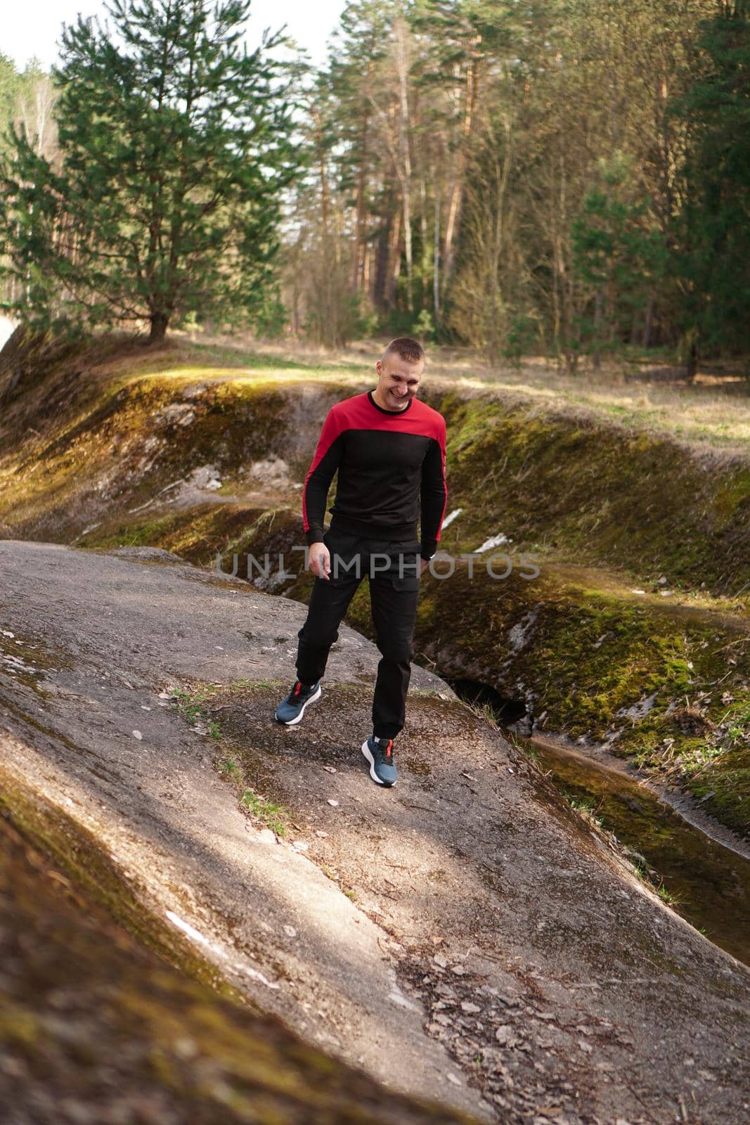 Young male athlete running in forest. Man jogging in the morning in the forest by natali_brill