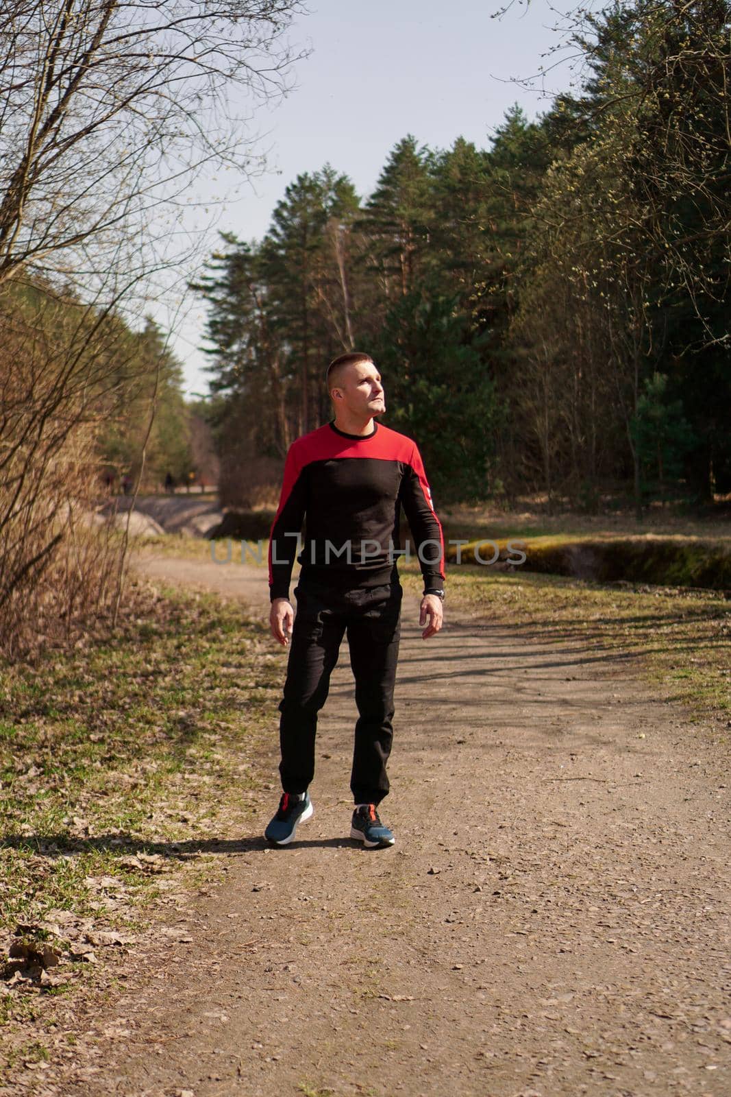 A man in sportswear on a forest path. A man after morning jog walks in the woods by natali_brill