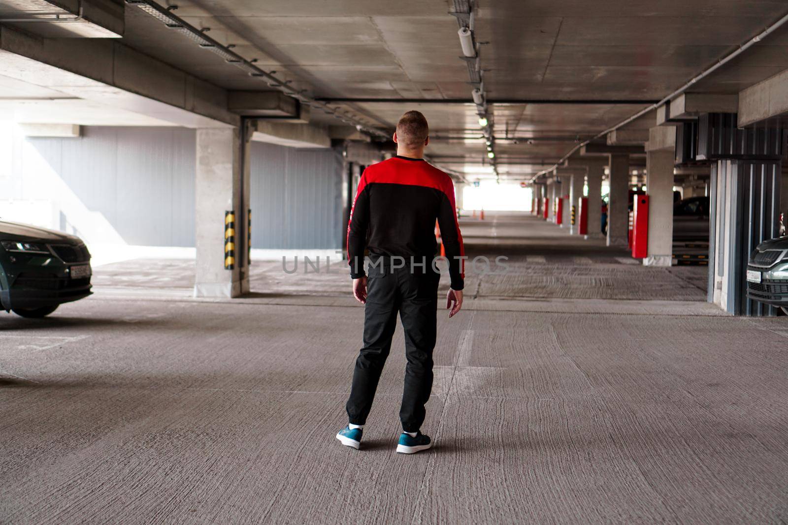 A young man in a sports uniform in an underground parking lot. by natali_brill