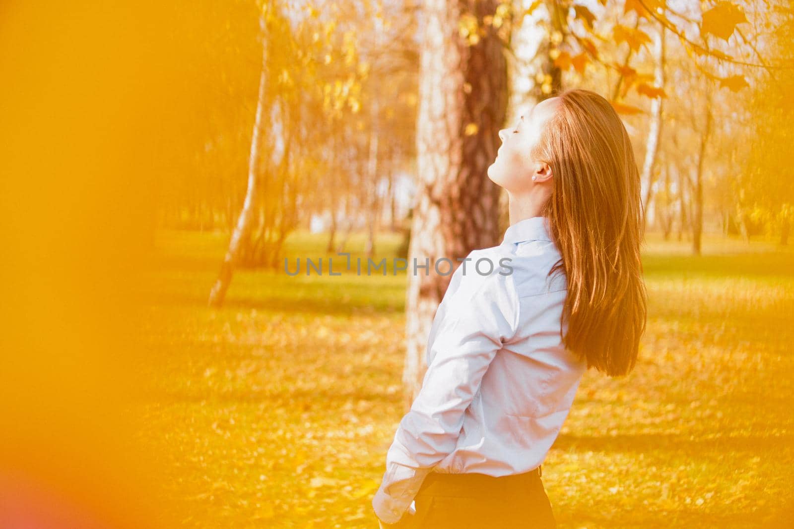 Portrait of beautiful young woman in autumn park - sunny day