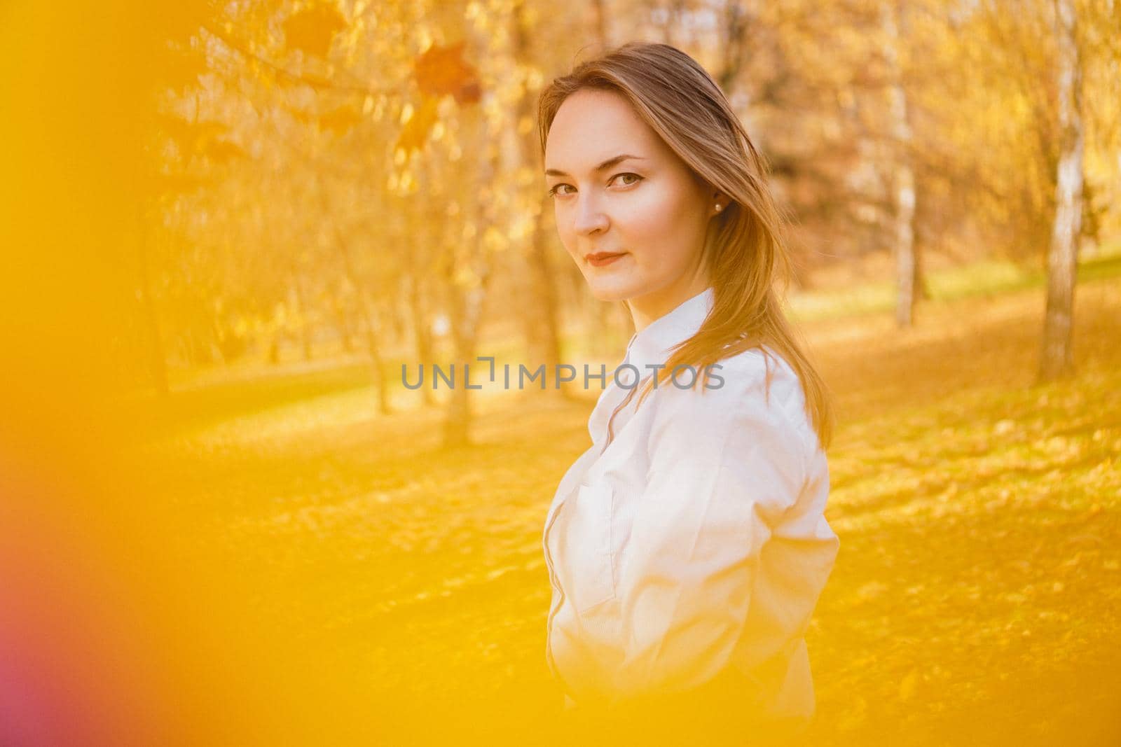 Portrait of beautiful young woman in autumn park - sunny day