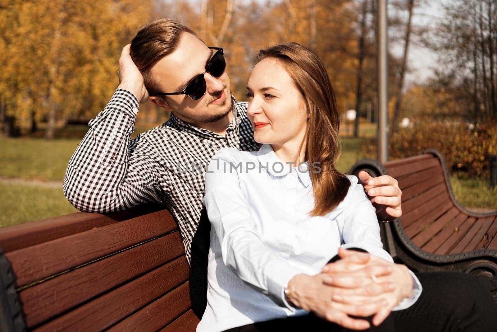 Happy smiling couple on park bench in fall by natali_brill