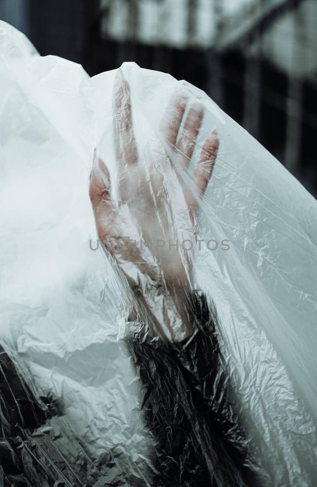 Ecology concept. Girl with plastic wrap - Hand raised . City Style. Urban photo