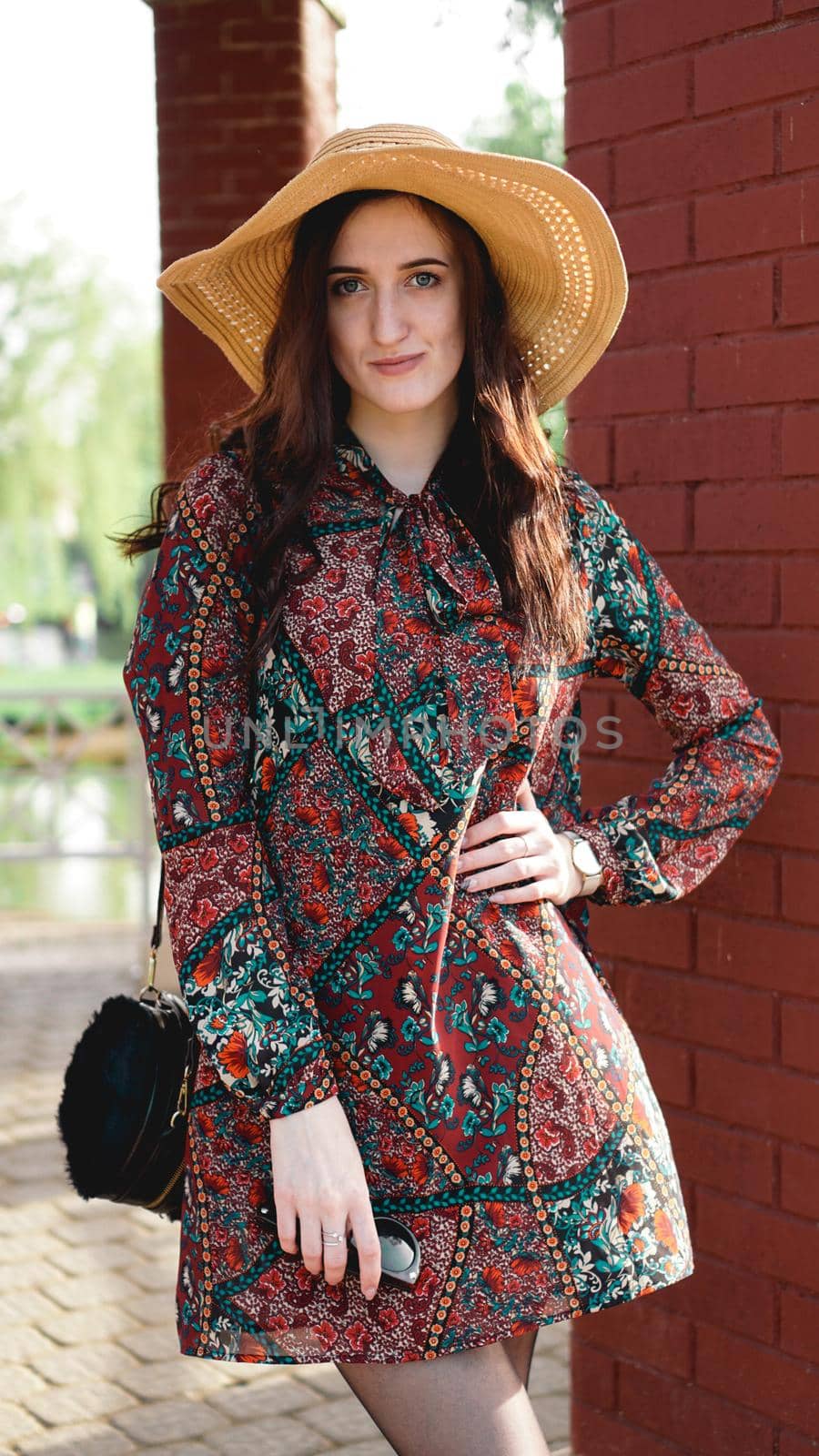 Portrait of pretty woman wearing dress and straw hat in sunny warm weather day by natali_brill