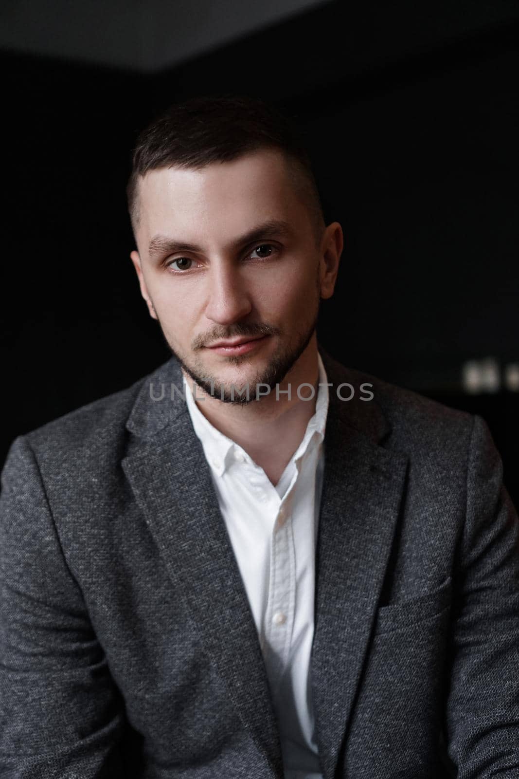 Portrait of a young attractive handsome elegant man on dark background