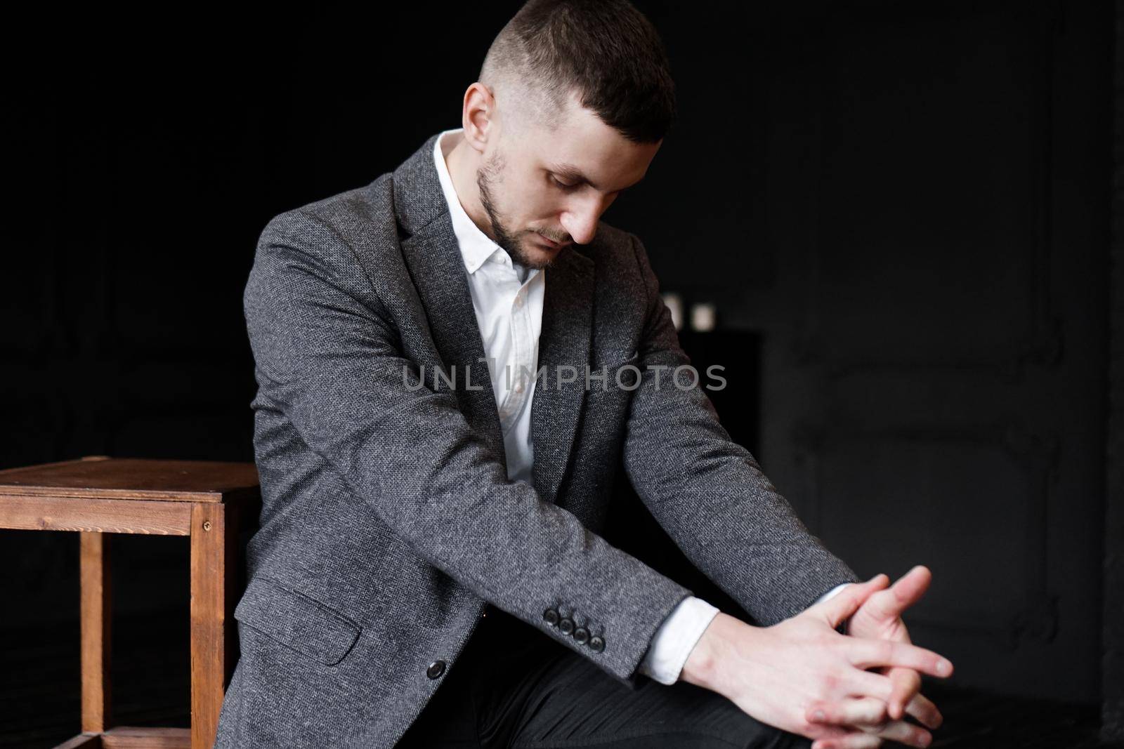 Portrait of succesful business man in formal suit looking down. Gray background