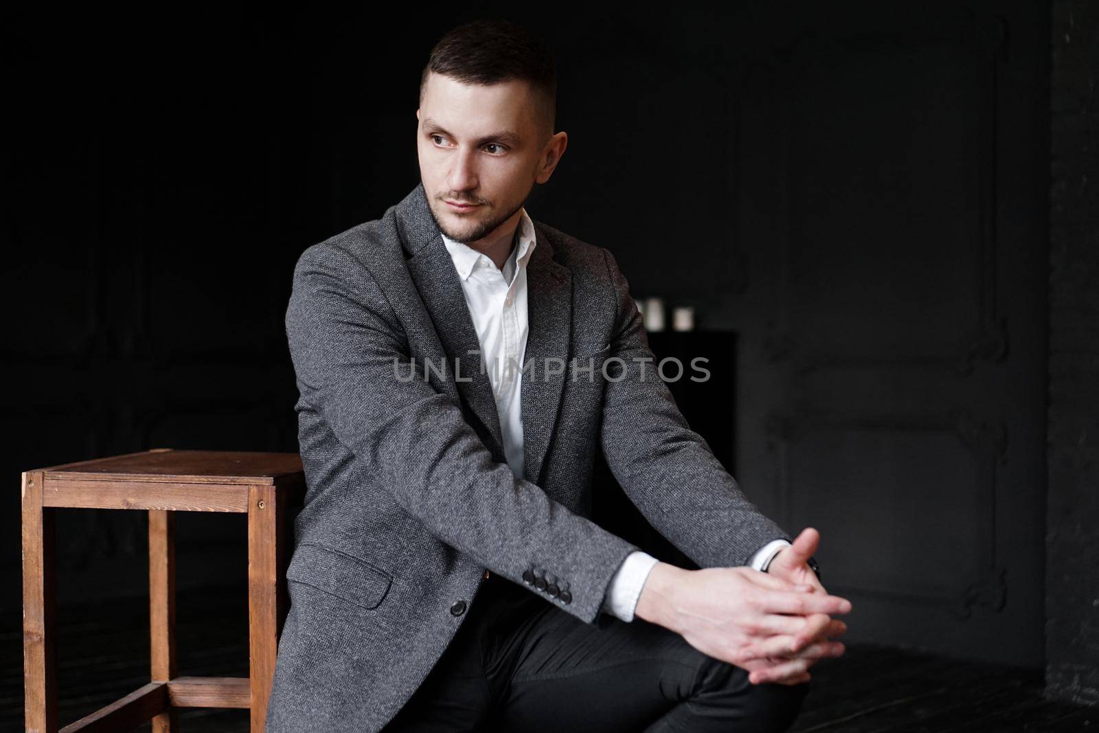 Portrait of a young attractive handsome elegant man on dark background