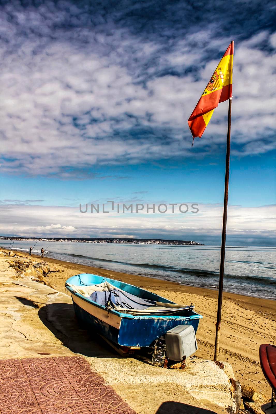 Fishing boats on the shore under spanish flag in the morning