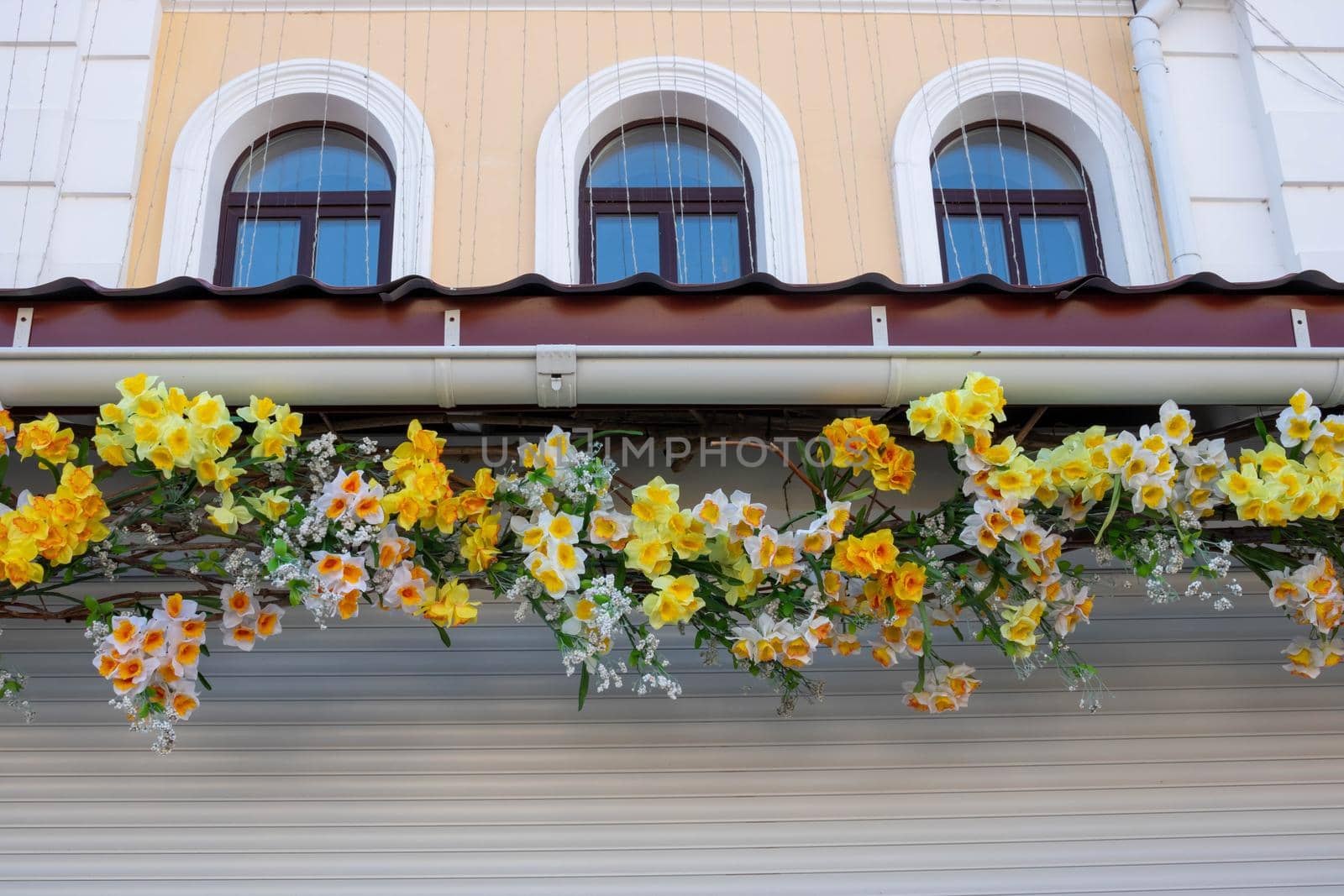 On the facade is a beautiful garland of artificial flowers white and yellow daffodils by lapushka62