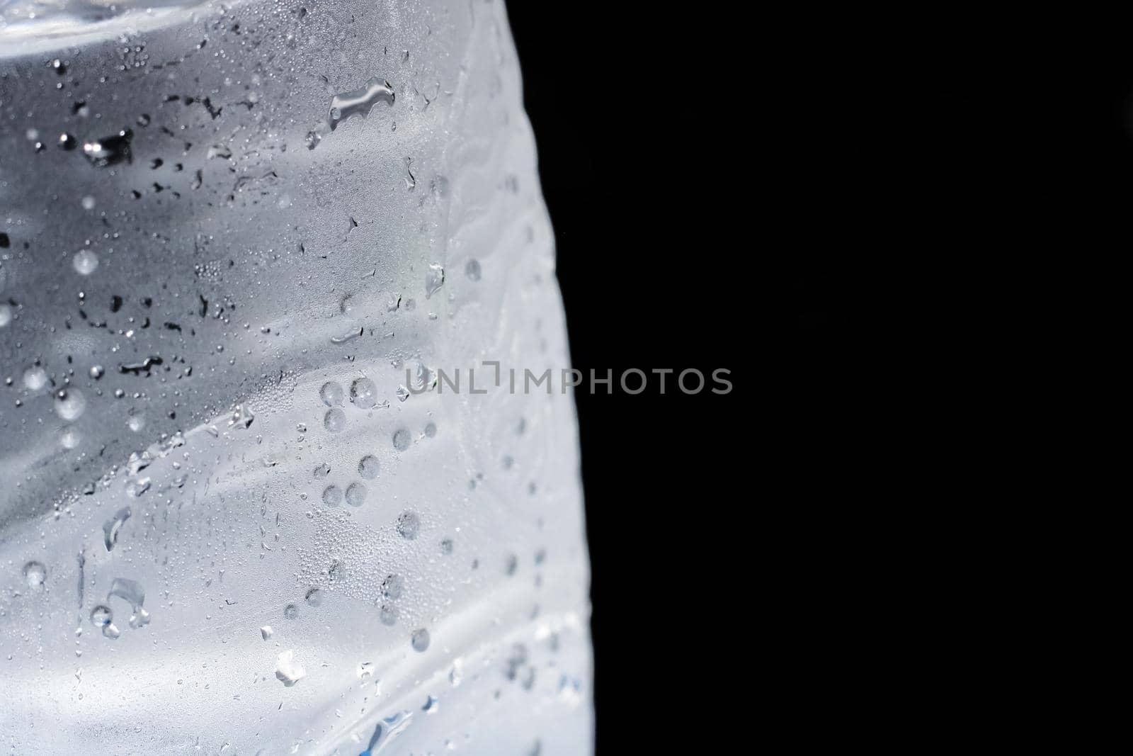 Bubbles in a cold water bottle on a black background close up