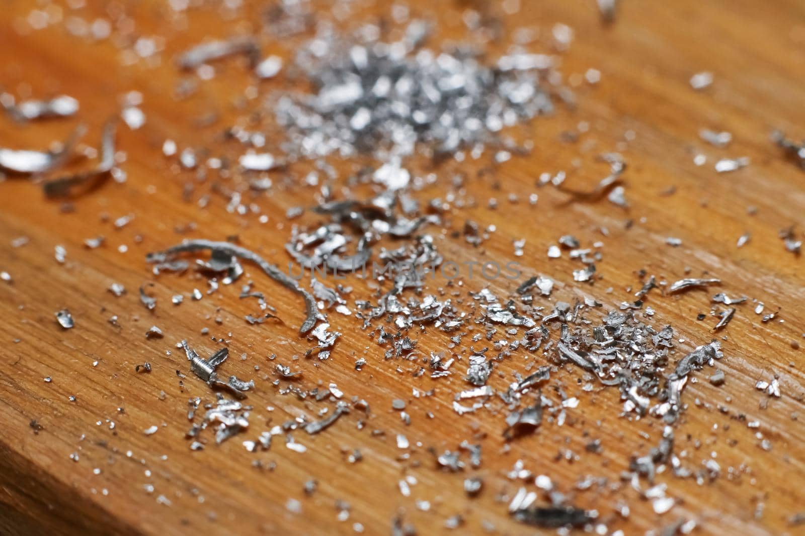 Small metal chips on a wooden background close up