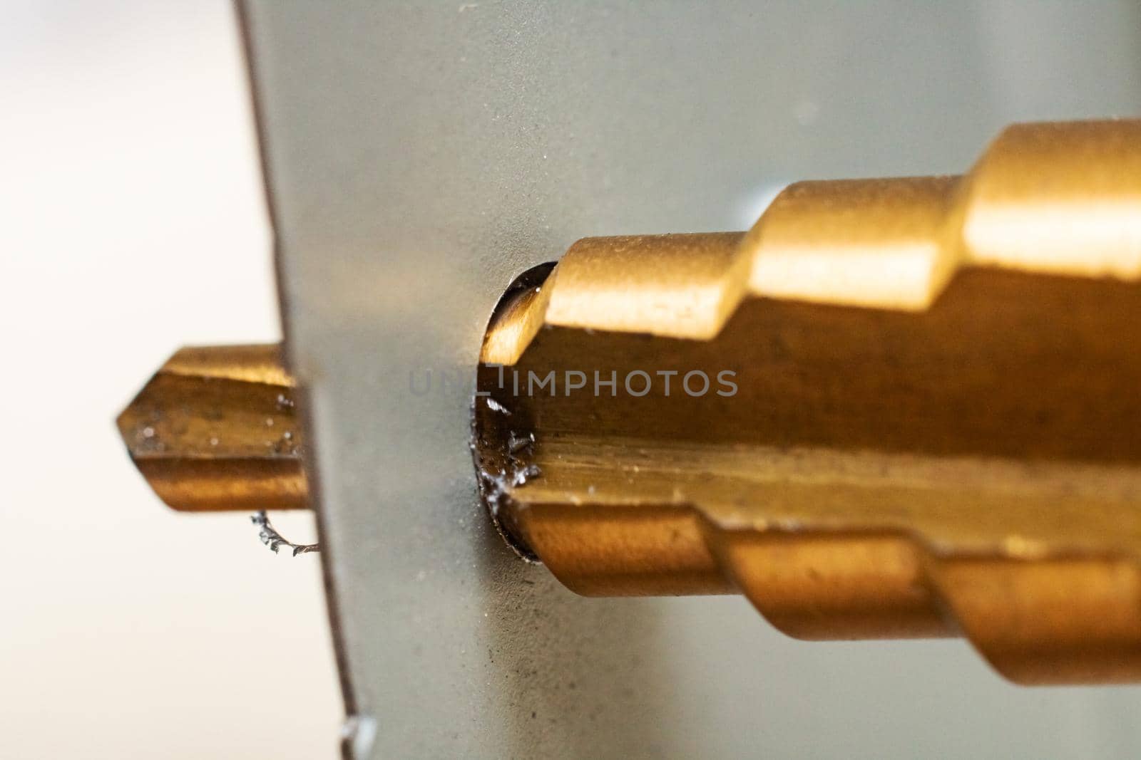 Multistage drill in sheet metal close up, macro photo