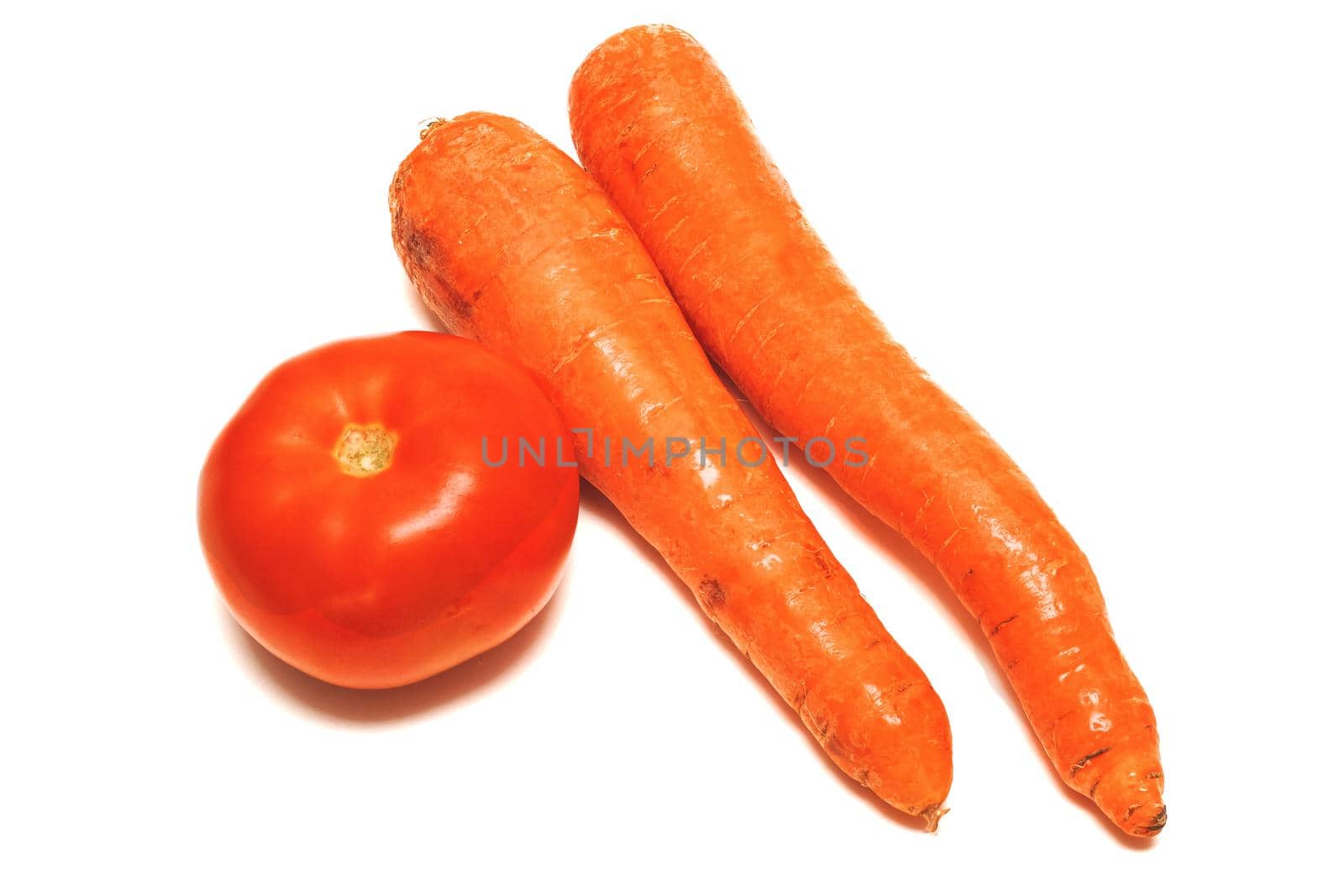 Red tomato and two carrots close up, isolated on white background