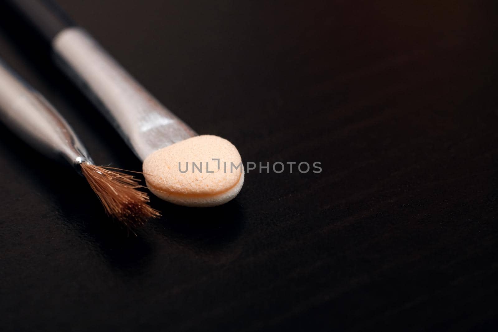 A set of brushes for applying makeup close-up on a dark background, copy space