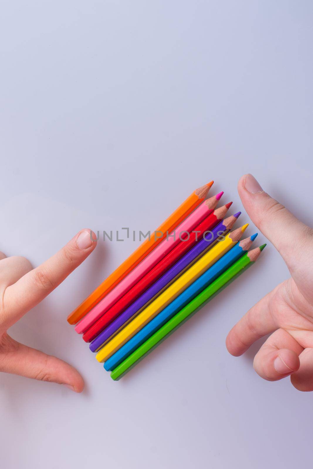 Hand holding color Pencils placed on a white background