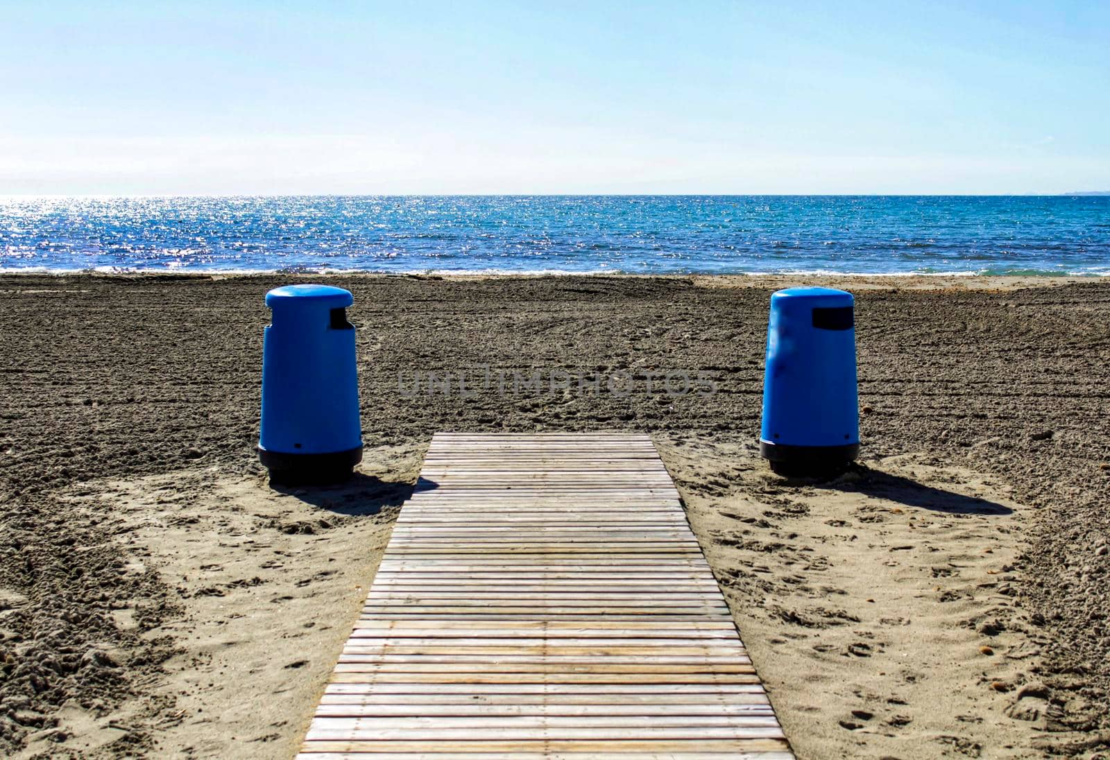 Wastebaskets and walkway to the beach in the morning