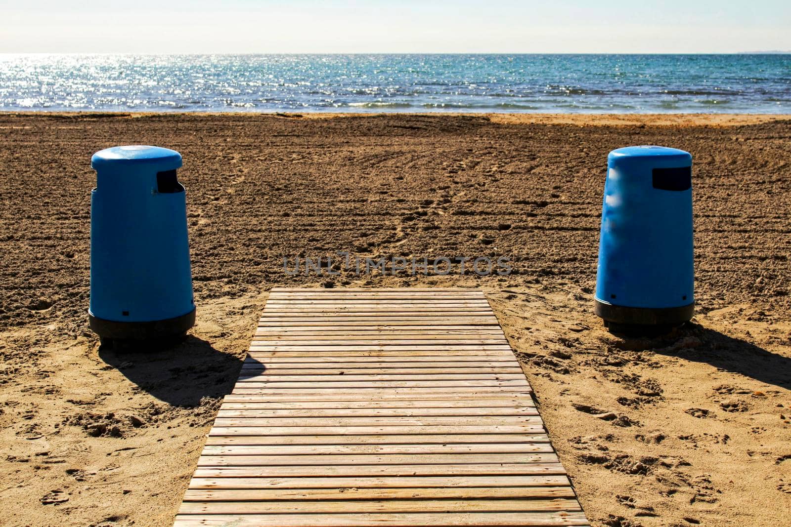 Wastebaskets and walkway to the beach in the morning