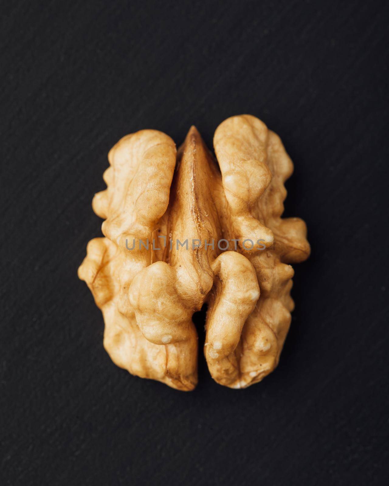 shelled walnut on black background by nikkytok