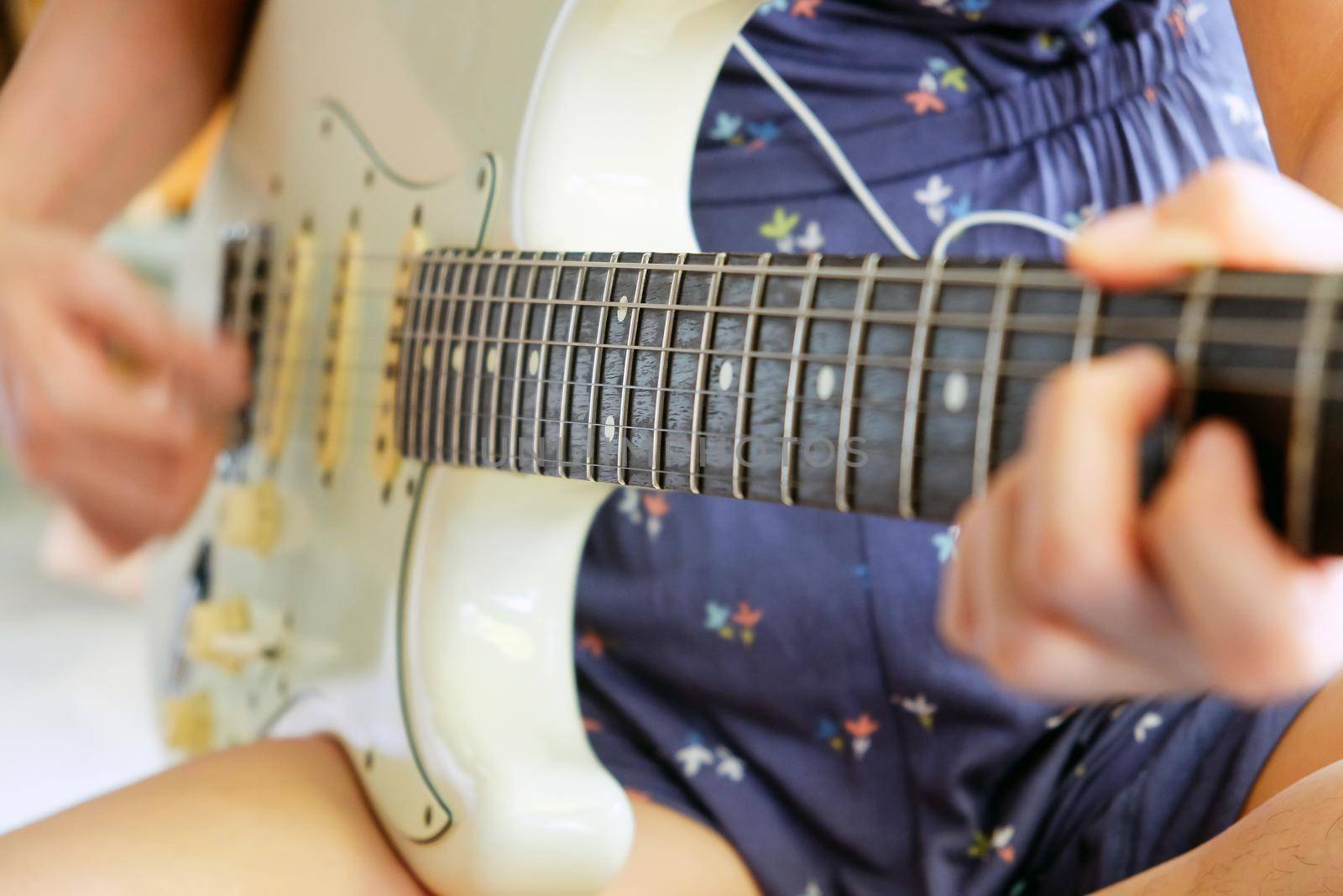 Woman hands playing electric guitar close up