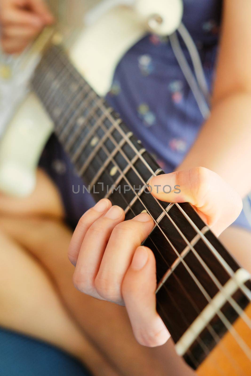 Woman hands playing electric guitar close up