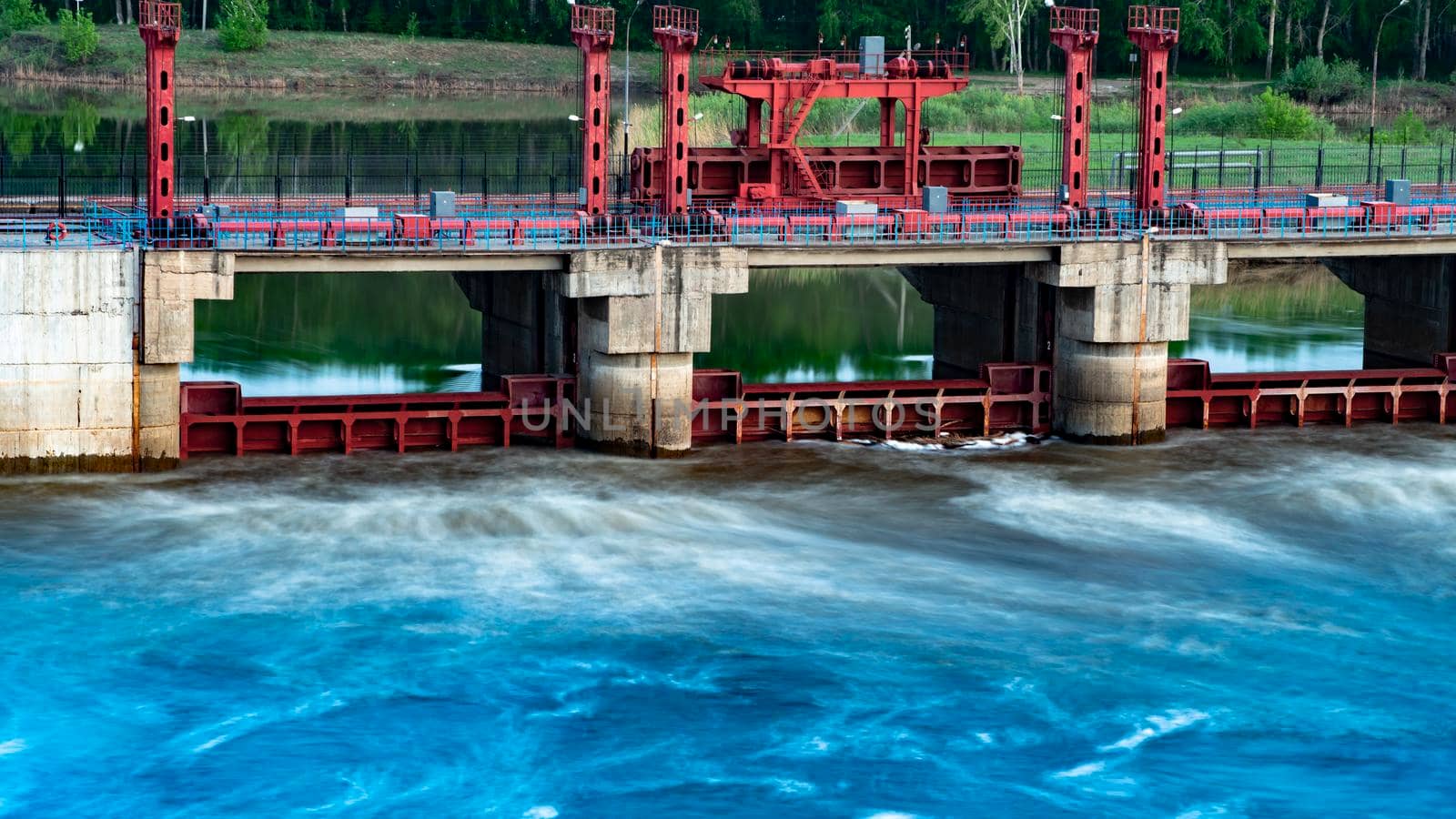 River, dam, bridge. Car and pedestrian bridge in the morning. A full-flowing river with a strong current. Clean, bubbling, fresh water.Technical construction on the river, fresh water reserves