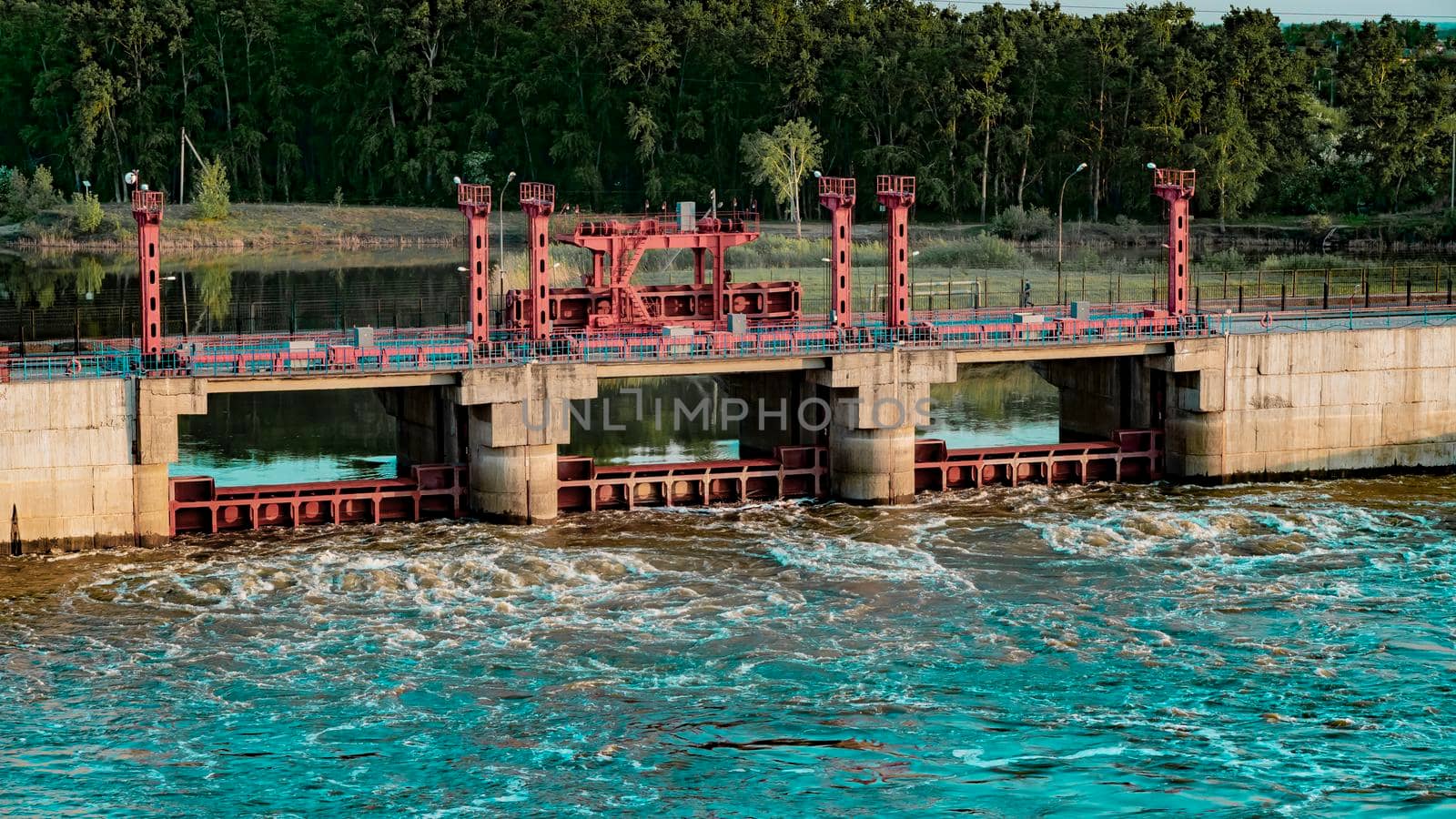 River, dam, bridge. Car and pedestrian bridge in the morning. A full-flowing river with a strong current. Clean, bubbling, fresh water.Technical construction on the river, fresh water reserves