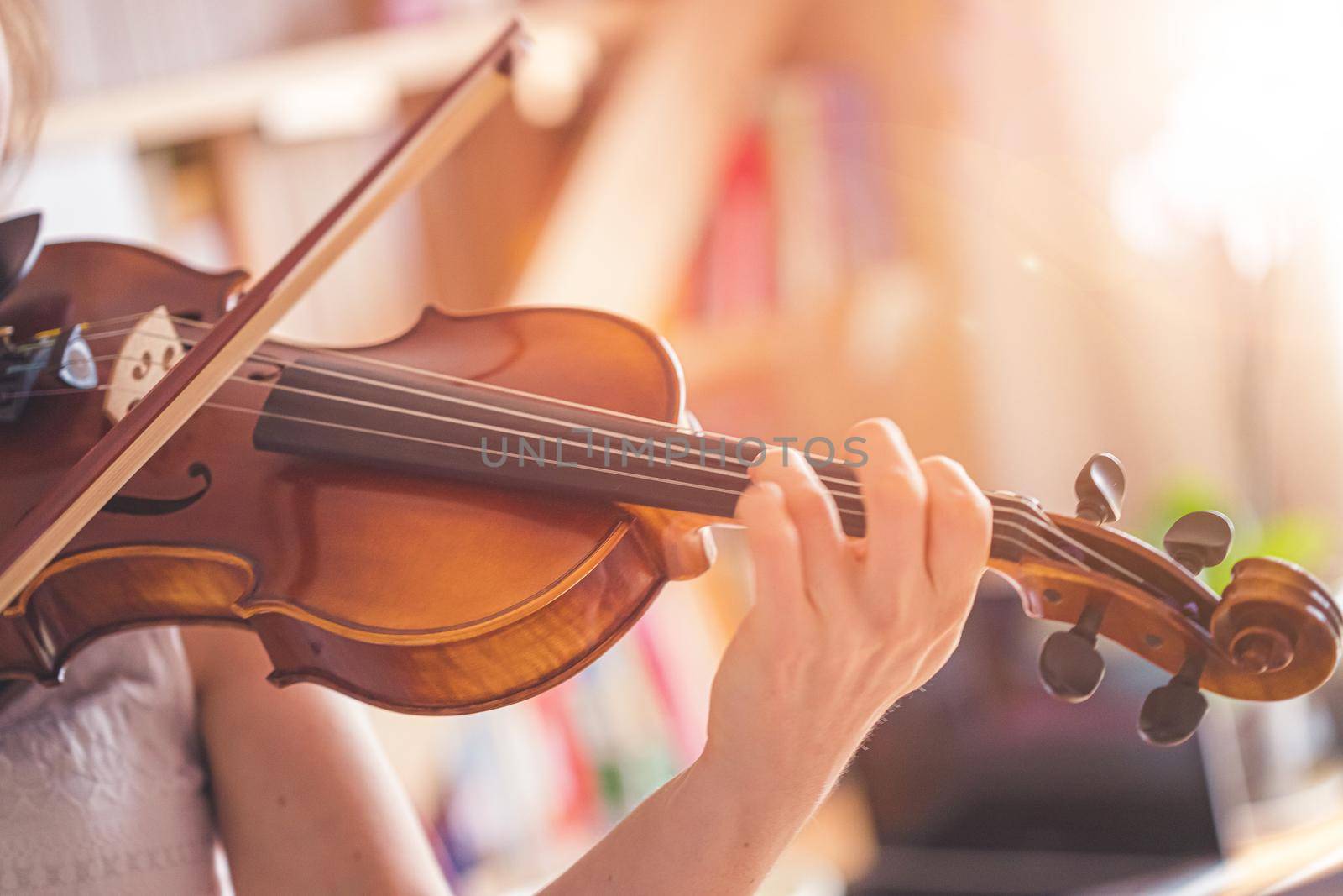 Practicing classical music and violin concept: Young girl happily plays on her new violin by Daxenbichler