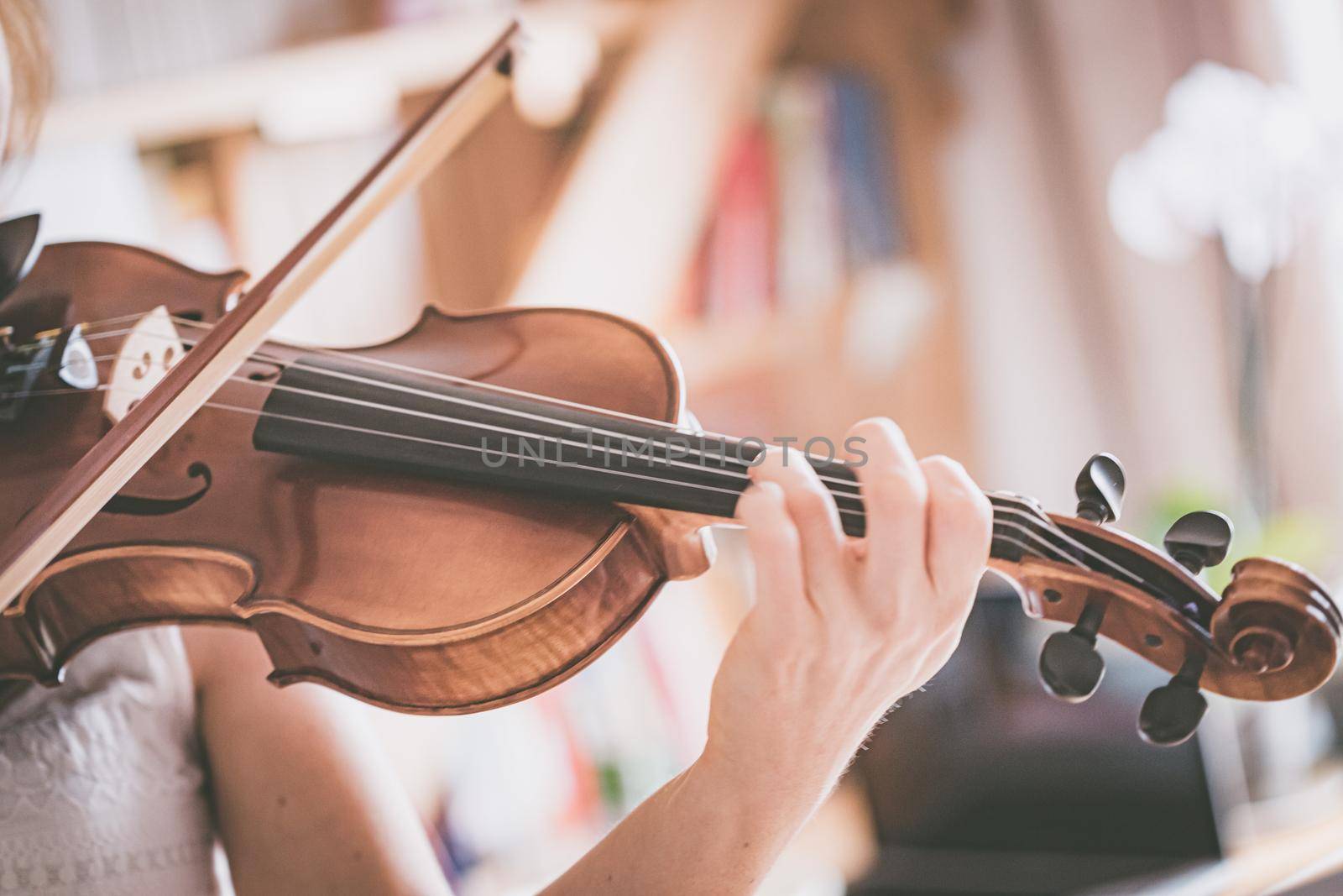 Practicing classical music and violin concept: Young girl happily plays on her new violin by Daxenbichler