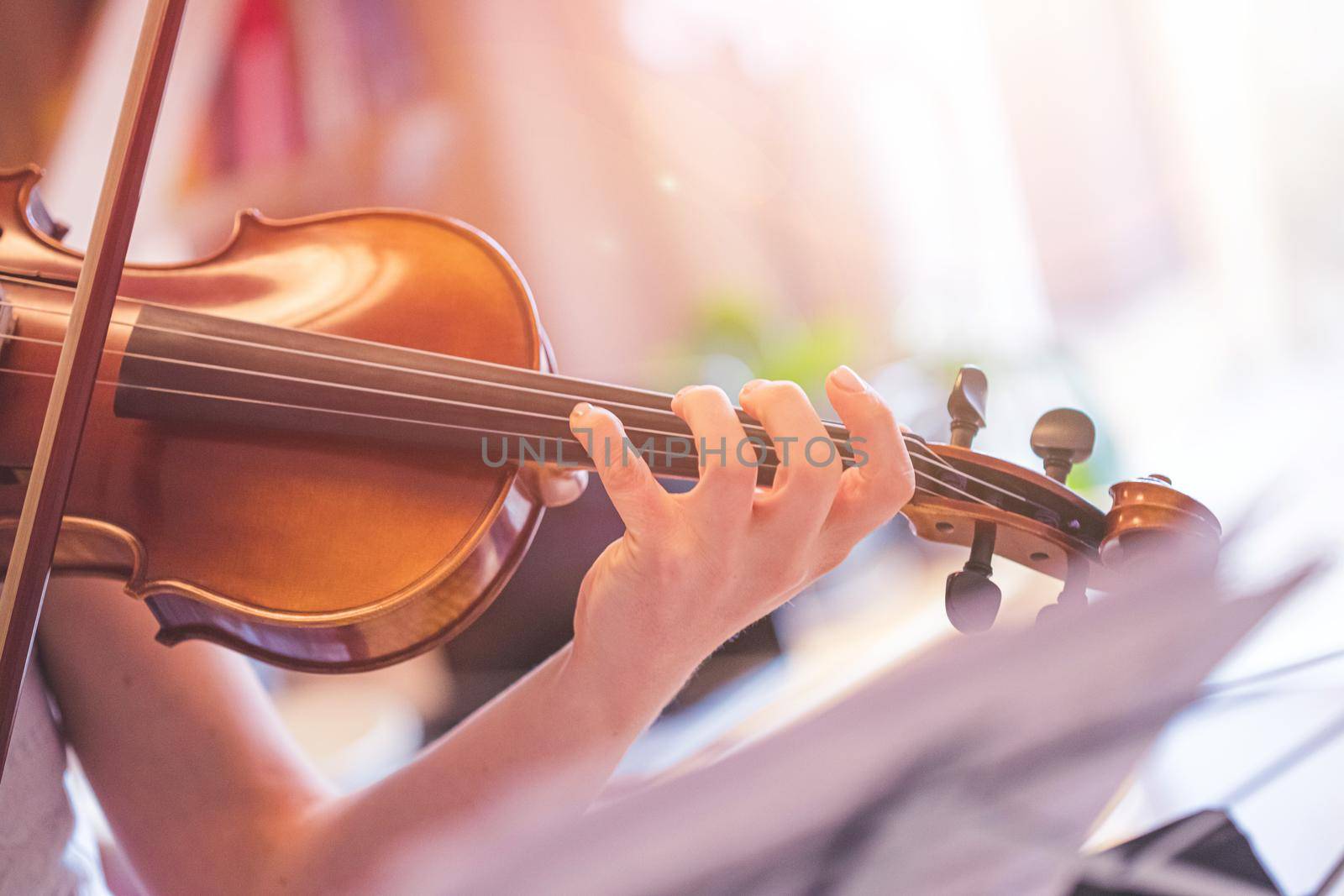 Practicing classical music and violin concept: Young girl happily plays on her new violin by Daxenbichler