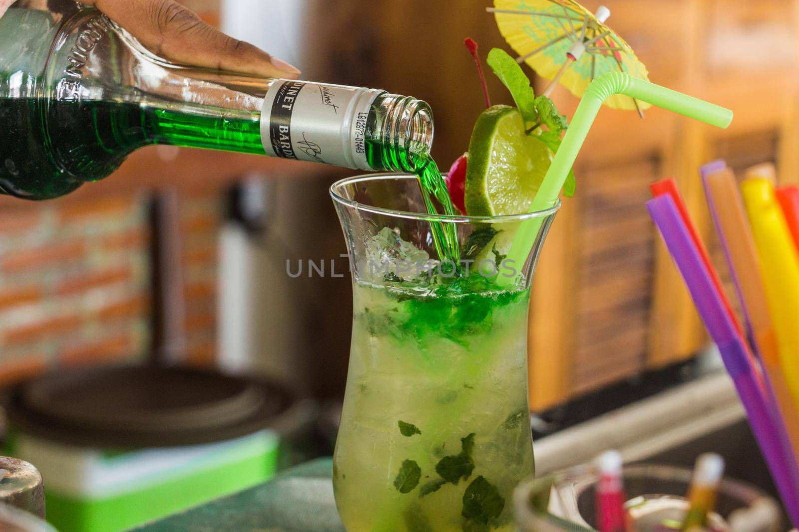 Mixing a green cocktail with alcohol and soda