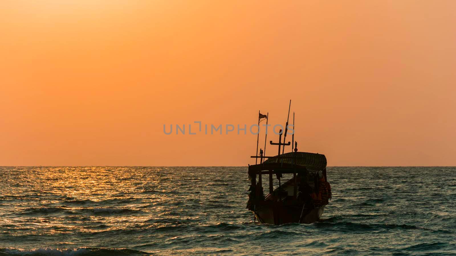 a silhouette boat on the ocean, coastline at sunrise, bule and orange colors