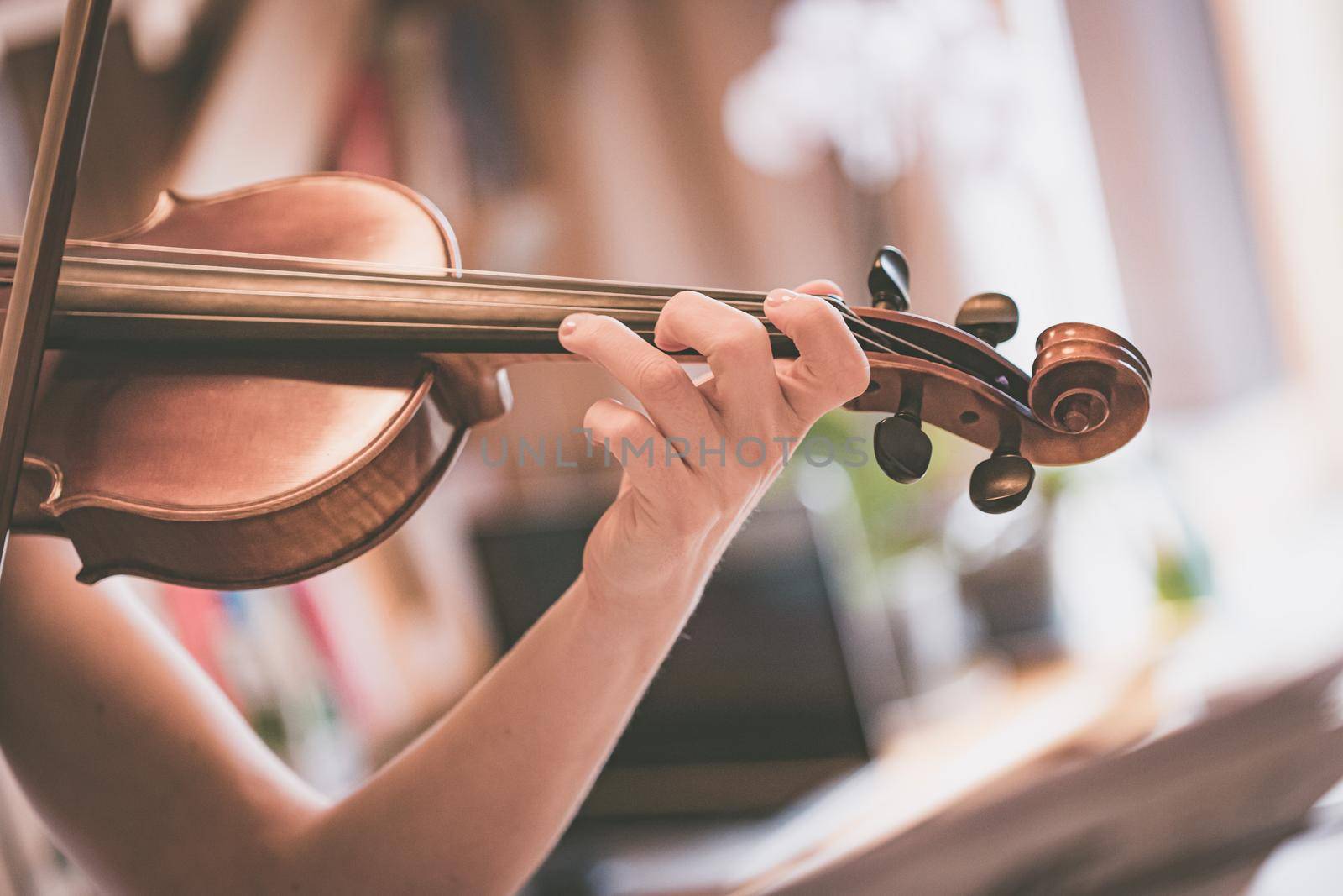 Practicing classical music and violin concept: Young girl happily plays on her new violin by Daxenbichler