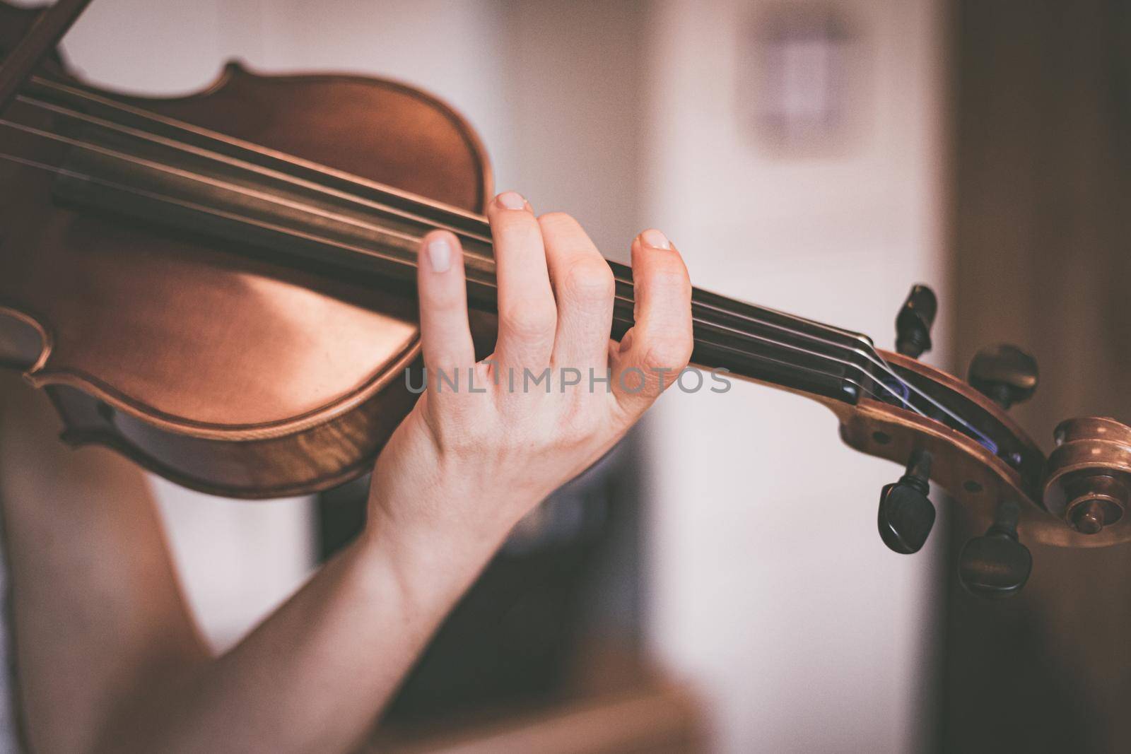 Practicing classical music and violin concept: Young girl happily plays on her new violin by Daxenbichler