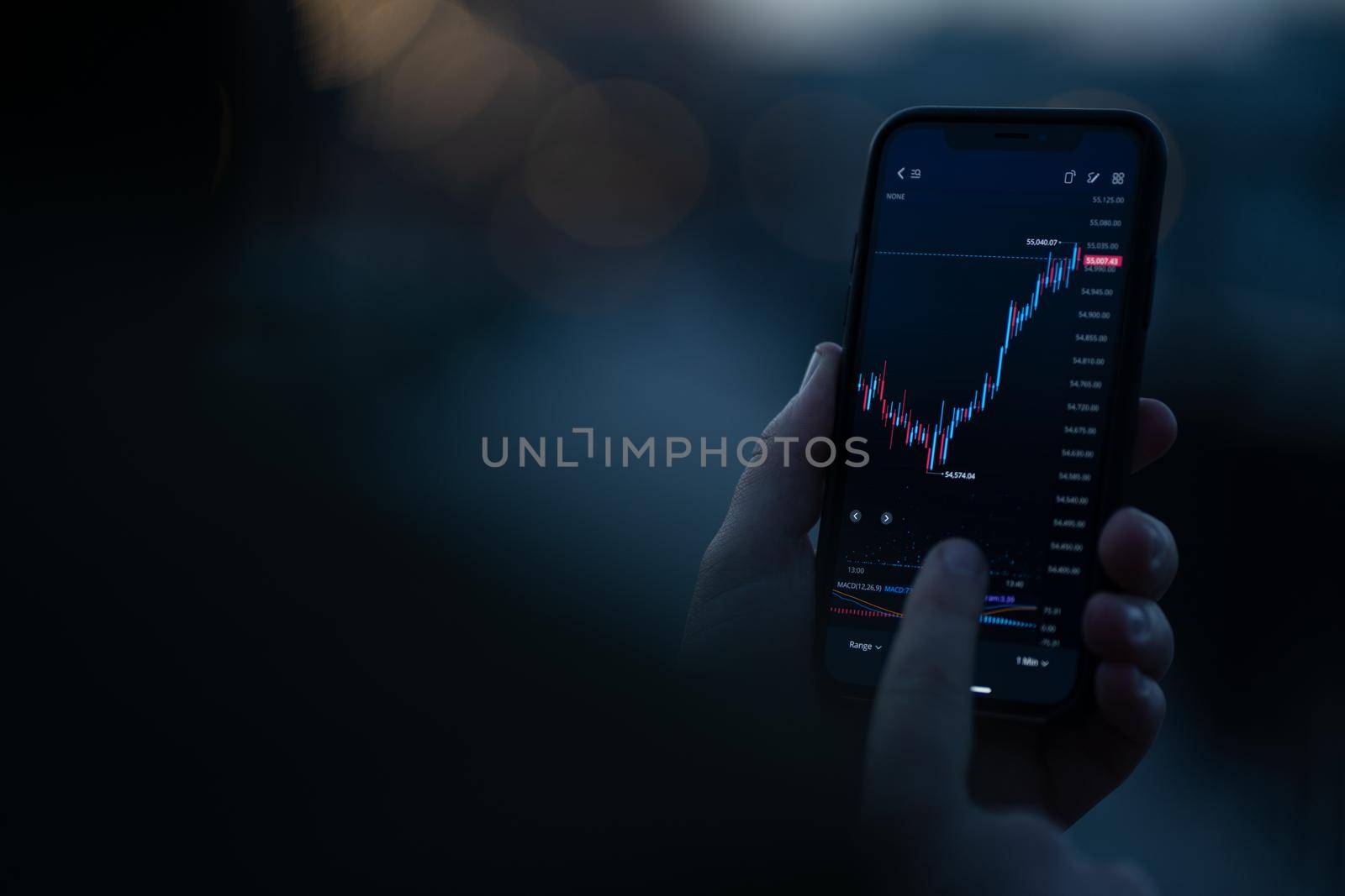 Investing online. Male hand monitoring stock exchange data on smartphone, using investment app for analyzing price activity in real time. Selective focus on mobile phone with financial chart on screen