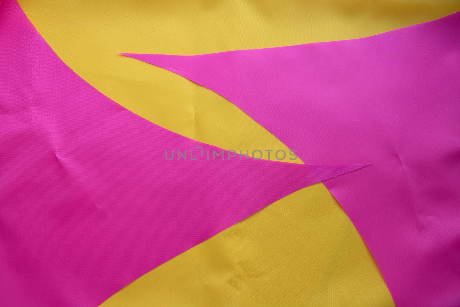 Pink pieces of fabric lie on the yellow fabric.