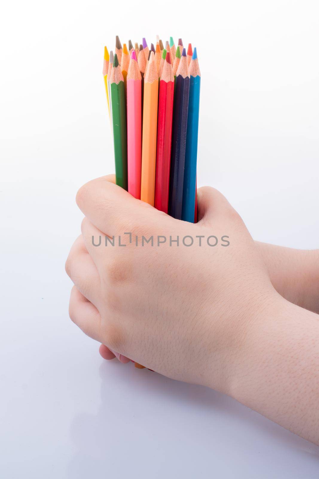 Hand holding color Pencils placed on a white background