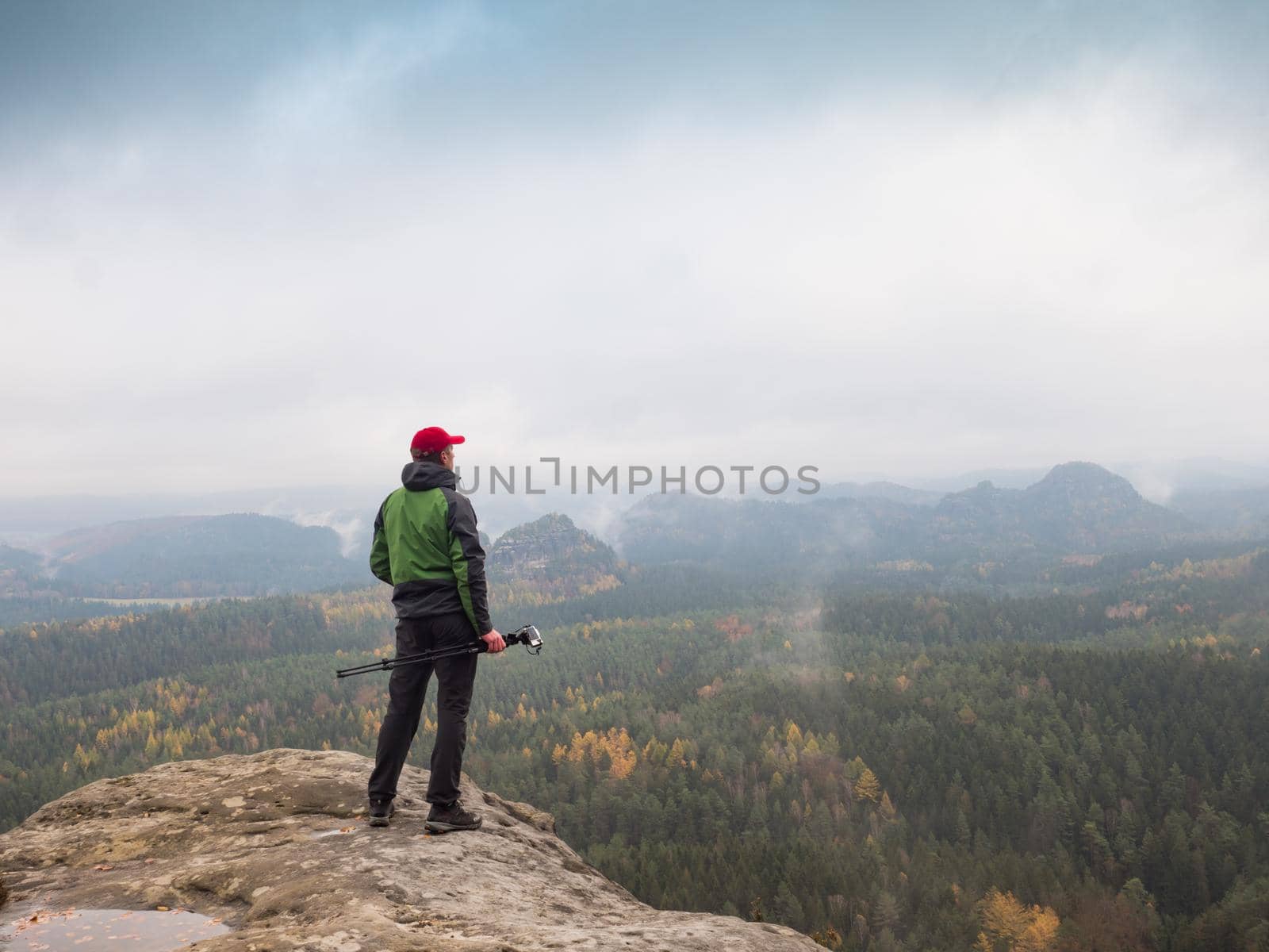 Photographer at misty sunrise. Rainy misty fall day