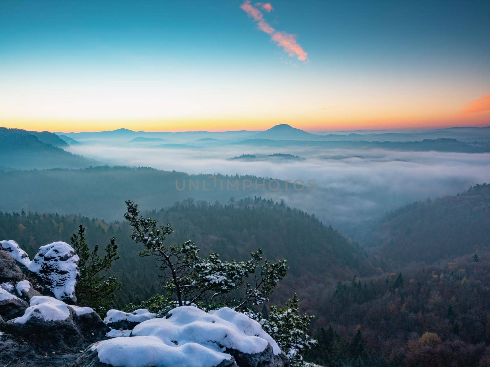 Snowy peak early morning.  Chill awaking in misty country. Morning sun hidden bellow  horizon