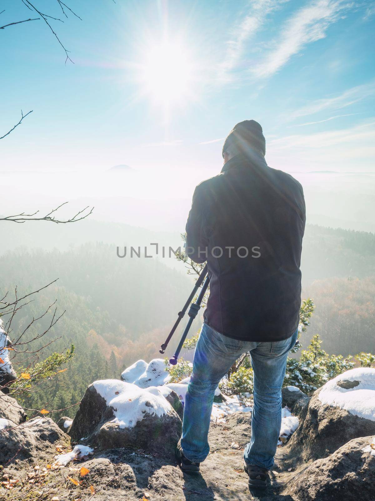 Nature photographer taking photos in the snowy mountains. Amazing winter morning