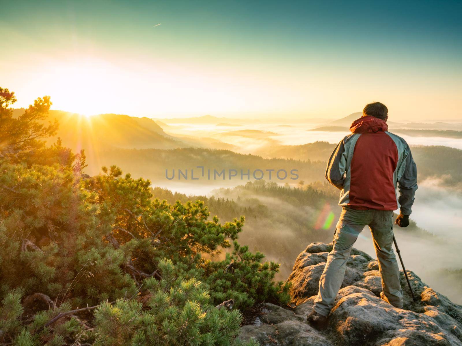 Photographer with digital camera making photo of morning misty country by rdonar2