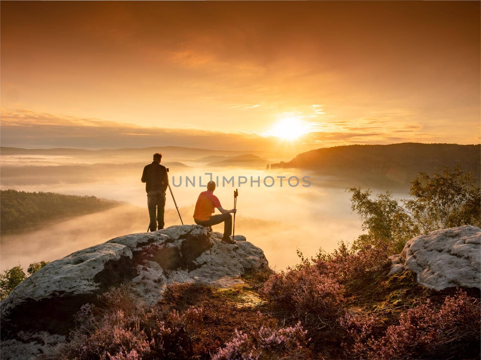 Matured man photographer at the hilltop with his tripod and camera by rdonar2