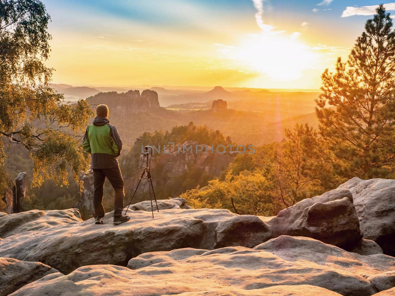 Man photographer staring into misty landscape of Saechsische Schweiz park. by rdonar2