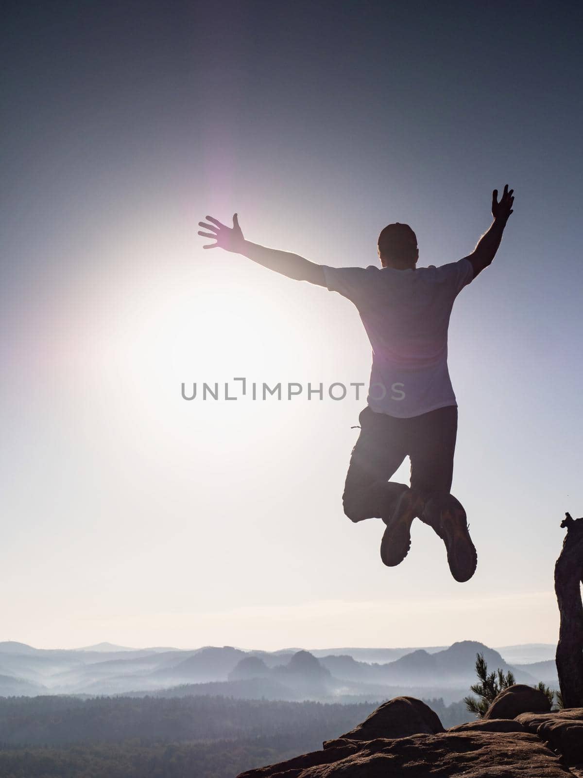 Success and freedom. The independence concept photo. Hiker jumps  by rdonar2